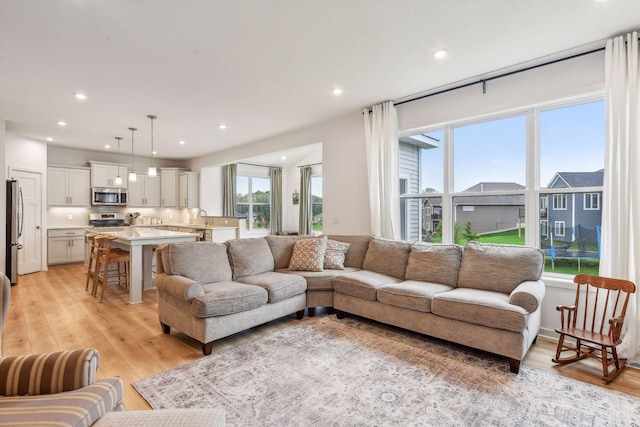 living area with light wood-style flooring and recessed lighting