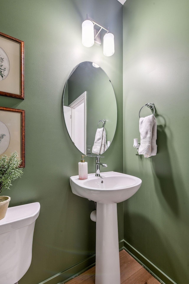 half bath featuring toilet and wood finished floors