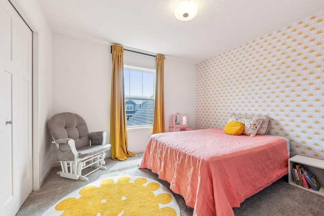 bedroom featuring baseboards, an accent wall, carpet flooring, and wallpapered walls