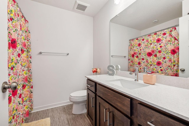 full bathroom featuring toilet, wood finished floors, vanity, visible vents, and baseboards