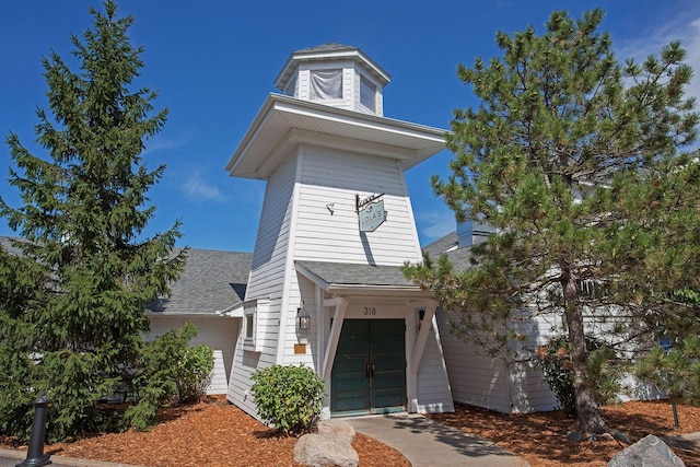 view of front facade featuring driveway, roof with shingles, and an attached garage