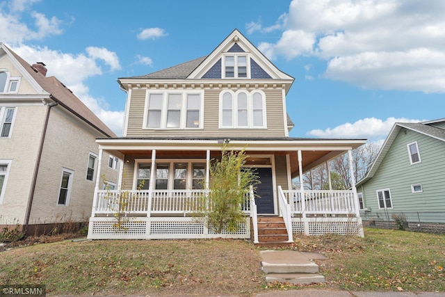 victorian home with covered porch and a front yard