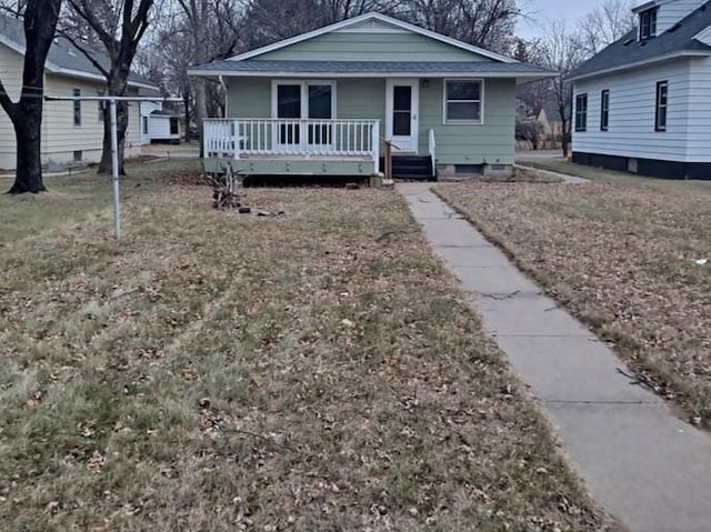 bungalow-style home featuring a front lawn and covered porch