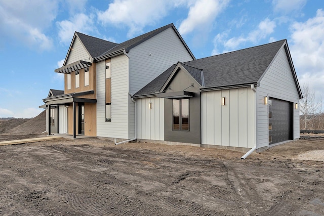 exterior space with roof with shingles and board and batten siding