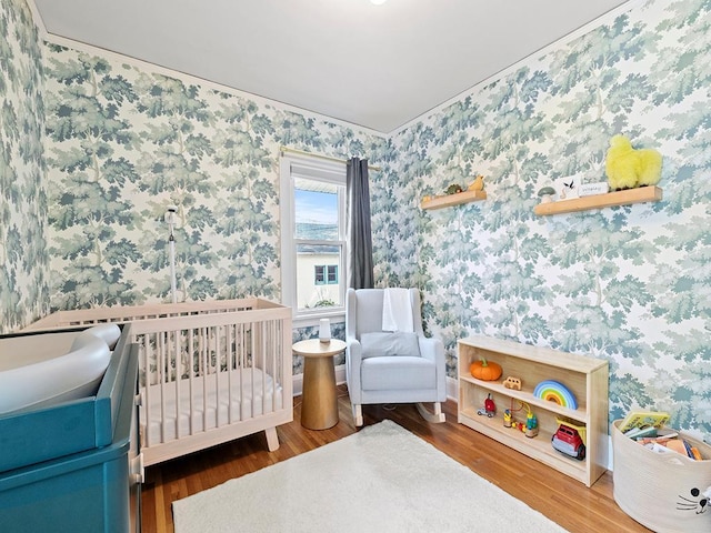 bedroom featuring hardwood / wood-style floors and a crib