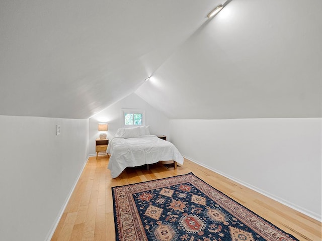 bedroom featuring vaulted ceiling and light wood-type flooring