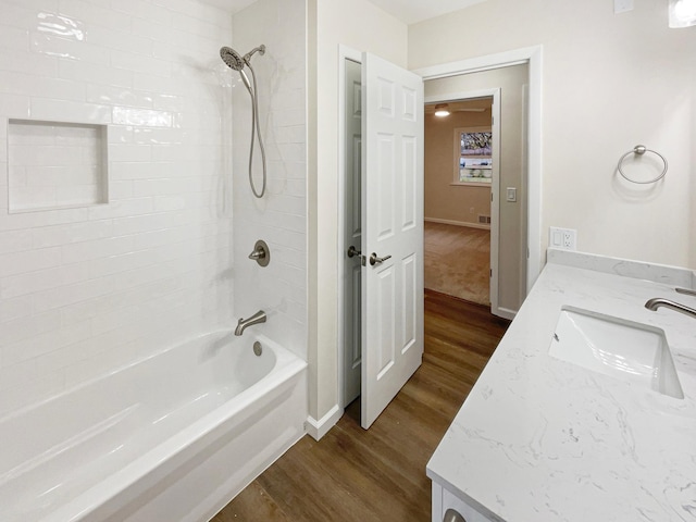 bathroom featuring hardwood / wood-style floors, vanity, and tiled shower / bath combo