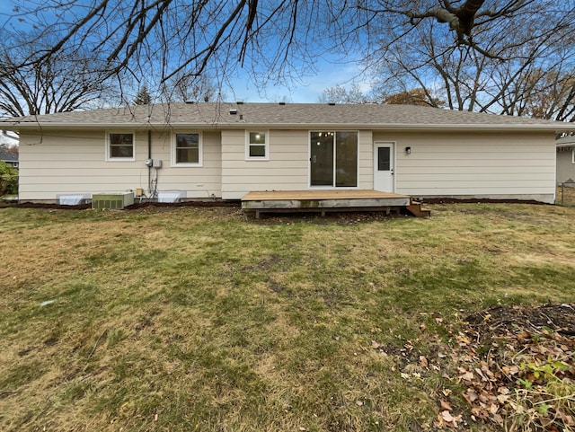 rear view of property with a yard, central AC unit, and a deck