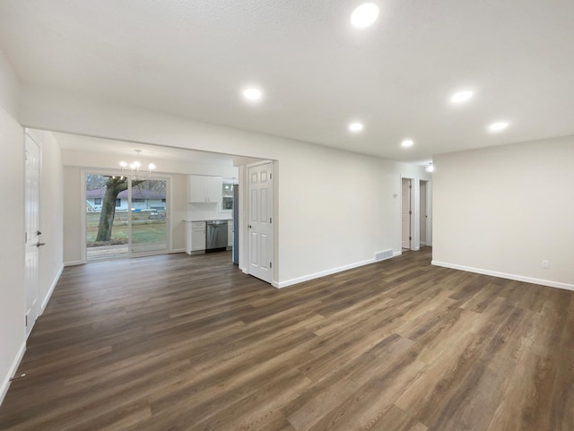 unfurnished living room with dark hardwood / wood-style flooring and an inviting chandelier