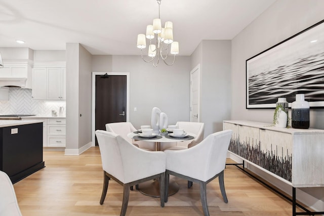 dining room featuring light wood-type flooring and a notable chandelier