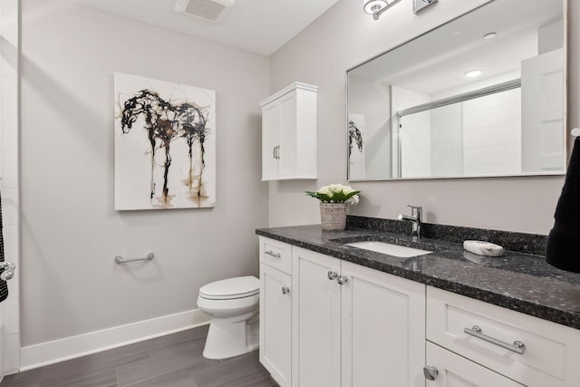 bathroom with hardwood / wood-style floors, vanity, toilet, and a shower with shower door