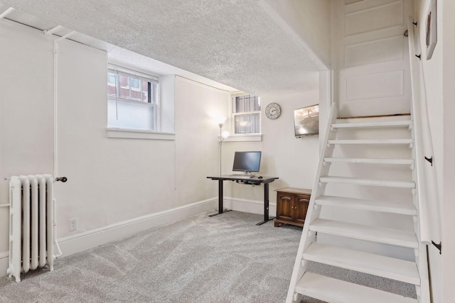 stairs with carpet, a textured ceiling, and radiator