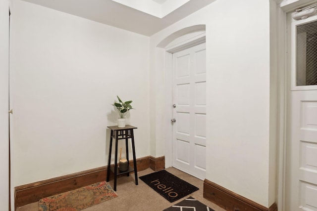 entrance foyer featuring dark colored carpet