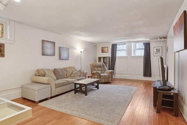 living room with light hardwood / wood-style floors and a textured ceiling