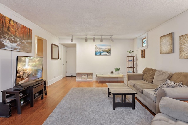 living room with crown molding, track lighting, a textured ceiling, and hardwood / wood-style flooring