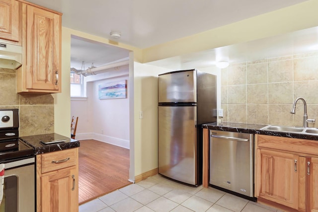 kitchen with decorative backsplash, light tile patterned flooring, sink, and appliances with stainless steel finishes