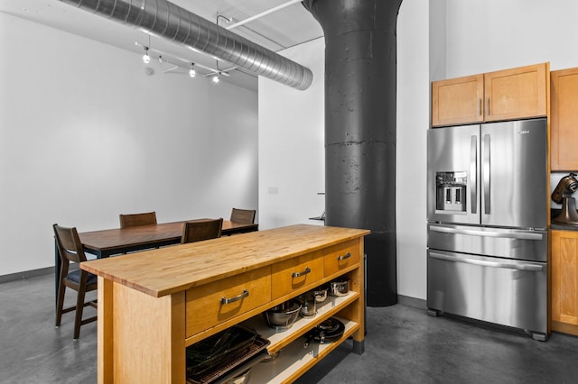 kitchen featuring stainless steel refrigerator with ice dispenser and butcher block counters