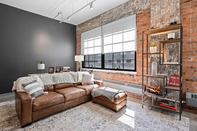 living room with radiator, brick wall, and track lighting