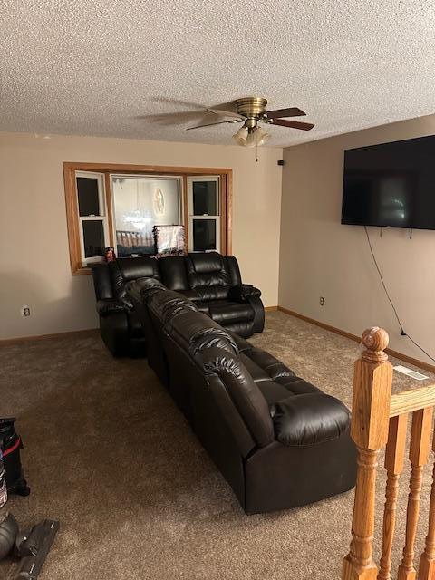 home theater room featuring carpet flooring, ceiling fan, and a textured ceiling