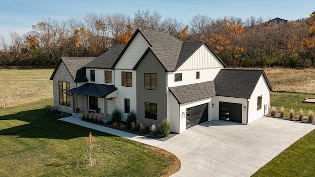 modern inspired farmhouse featuring a garage and a front yard