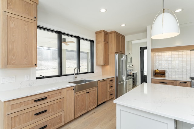 kitchen featuring sink, stainless steel appliances, light hardwood / wood-style floors, decorative backsplash, and decorative light fixtures