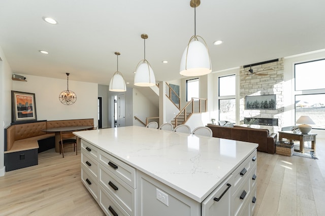 kitchen featuring pendant lighting, white cabinetry, light wood-type flooring, and a kitchen island