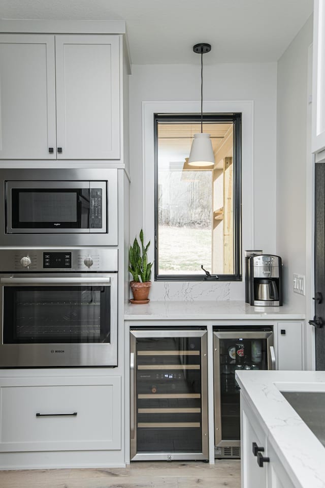 kitchen featuring white cabinetry, stainless steel appliances, and beverage cooler