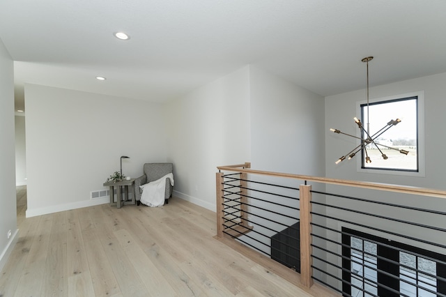 hallway with a notable chandelier and light hardwood / wood-style flooring