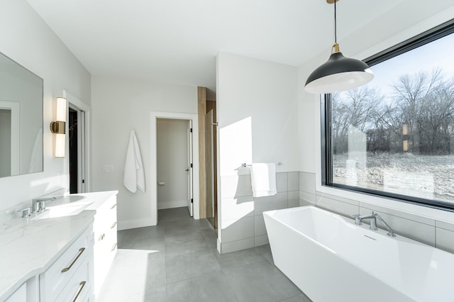 bathroom featuring tile patterned flooring, vanity, and a tub