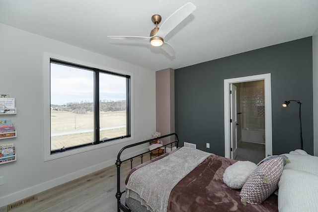 bedroom with ensuite bathroom, ceiling fan, and light wood-type flooring