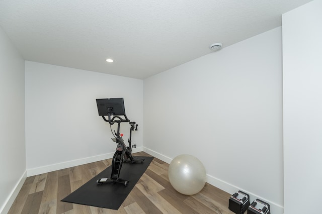 workout area with wood-type flooring and a textured ceiling