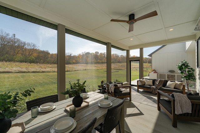 sunroom / solarium featuring a rural view and ceiling fan