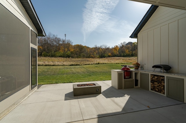 view of patio featuring exterior kitchen and a fire pit