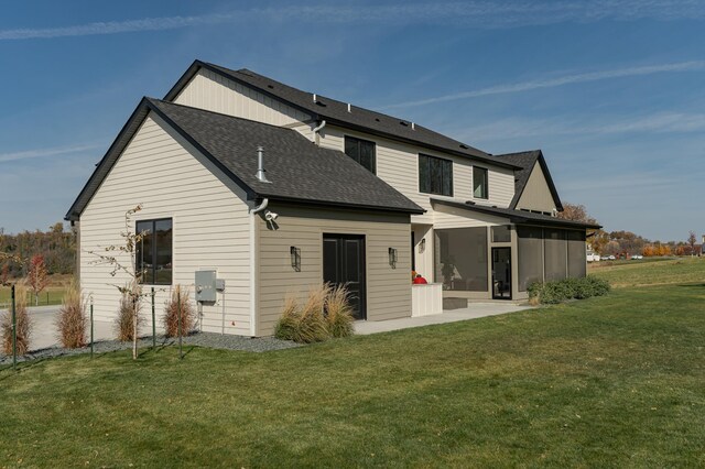 rear view of property featuring a lawn and a patio