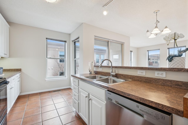 kitchen featuring stainless steel appliances, sink, light tile patterned floors, white cabinets, and hanging light fixtures