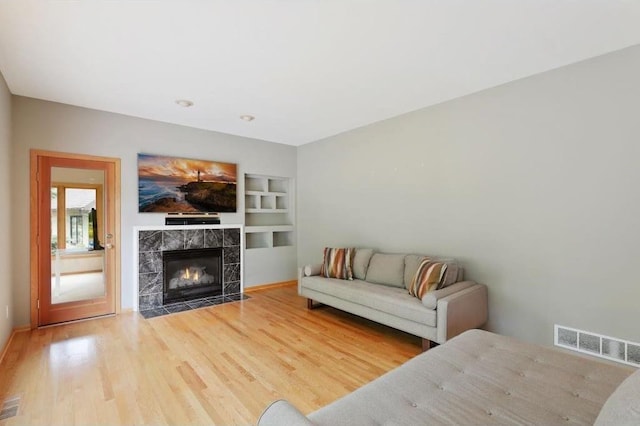 living room featuring hardwood / wood-style floors and a tiled fireplace