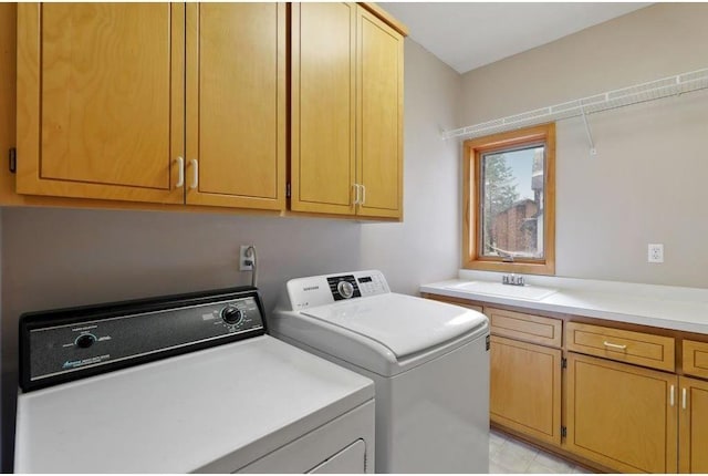 laundry area with separate washer and dryer, sink, and cabinets