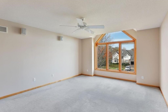 unfurnished room featuring ceiling fan, light carpet, and a textured ceiling