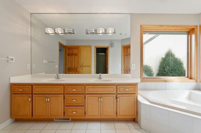 bathroom featuring vanity, tiled bath, and tile patterned floors