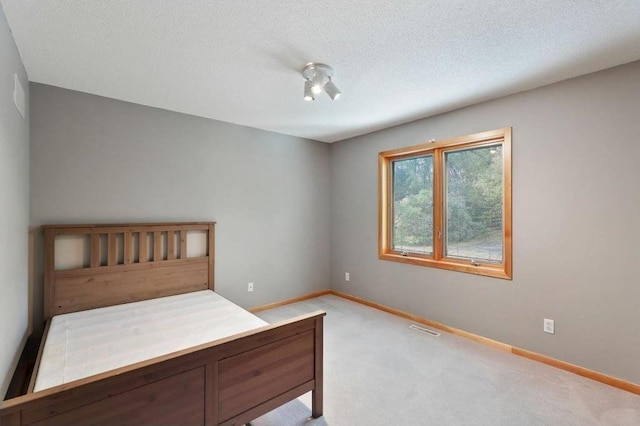 unfurnished bedroom featuring light colored carpet and a textured ceiling