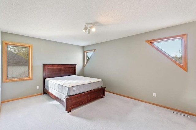 unfurnished bedroom with light carpet and a textured ceiling