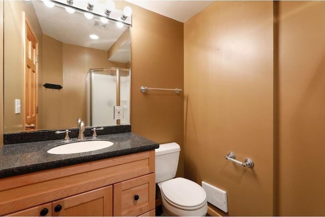 bathroom featuring vanity, toilet, and walk in shower