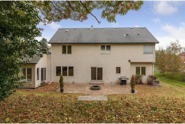 back of property featuring a fire pit and a patio area