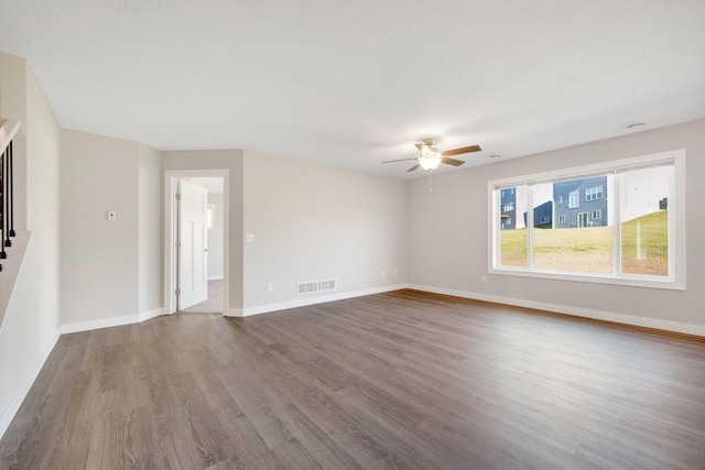 unfurnished room featuring ceiling fan, wood-type flooring, and a textured ceiling