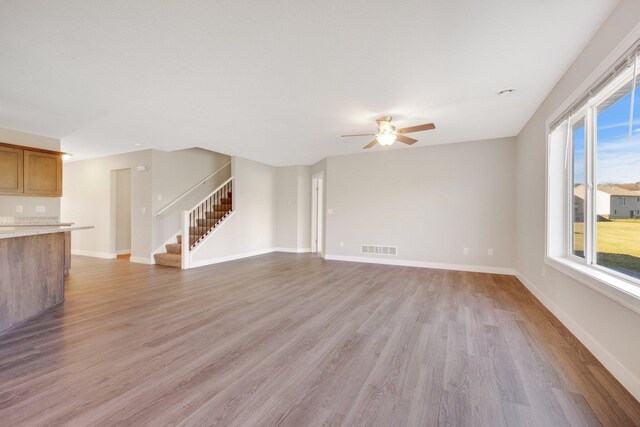 unfurnished living room featuring light hardwood / wood-style flooring and ceiling fan