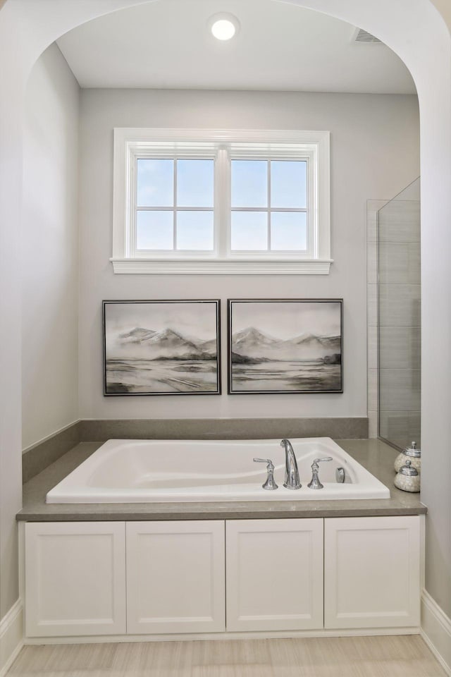 bathroom with a bathtub and a wealth of natural light