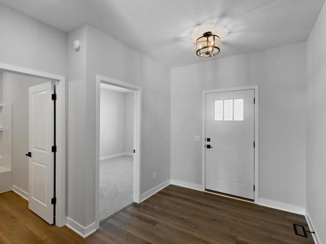 entryway featuring a textured ceiling and dark hardwood / wood-style flooring