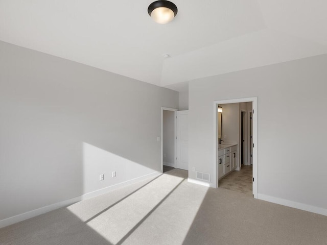 bedroom with light colored carpet and ensuite bathroom