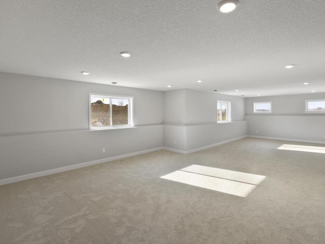 basement featuring light colored carpet and a textured ceiling