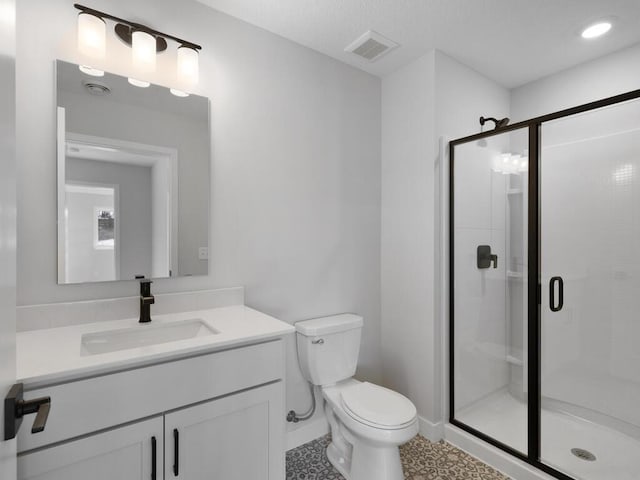 bathroom featuring vanity, toilet, an enclosed shower, and tile patterned flooring